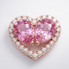 Heart-shaped pink gemstone ring with rose gold and diamond accents on a light gray background