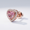 Heart-shaped pink gemstone earring with rose gold setting on a light gray background